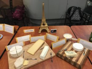 plates of cheese and a miniature Eiffel tower figurine on tables, French Club.   