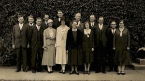 9 men in suits and 5 women in dresses stand together to take the 1931-1932 Pacific College faculty photograph. 