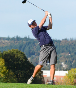 Bruins men's golf player swings a golf club.