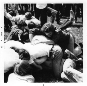 Students wrestle in a pile on grass for the bruin jr. 