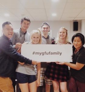 6 Transfer Students pose for a photo, holding a sign that reads "#mygfufamily"