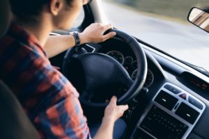 a young man behind the wheel of a car